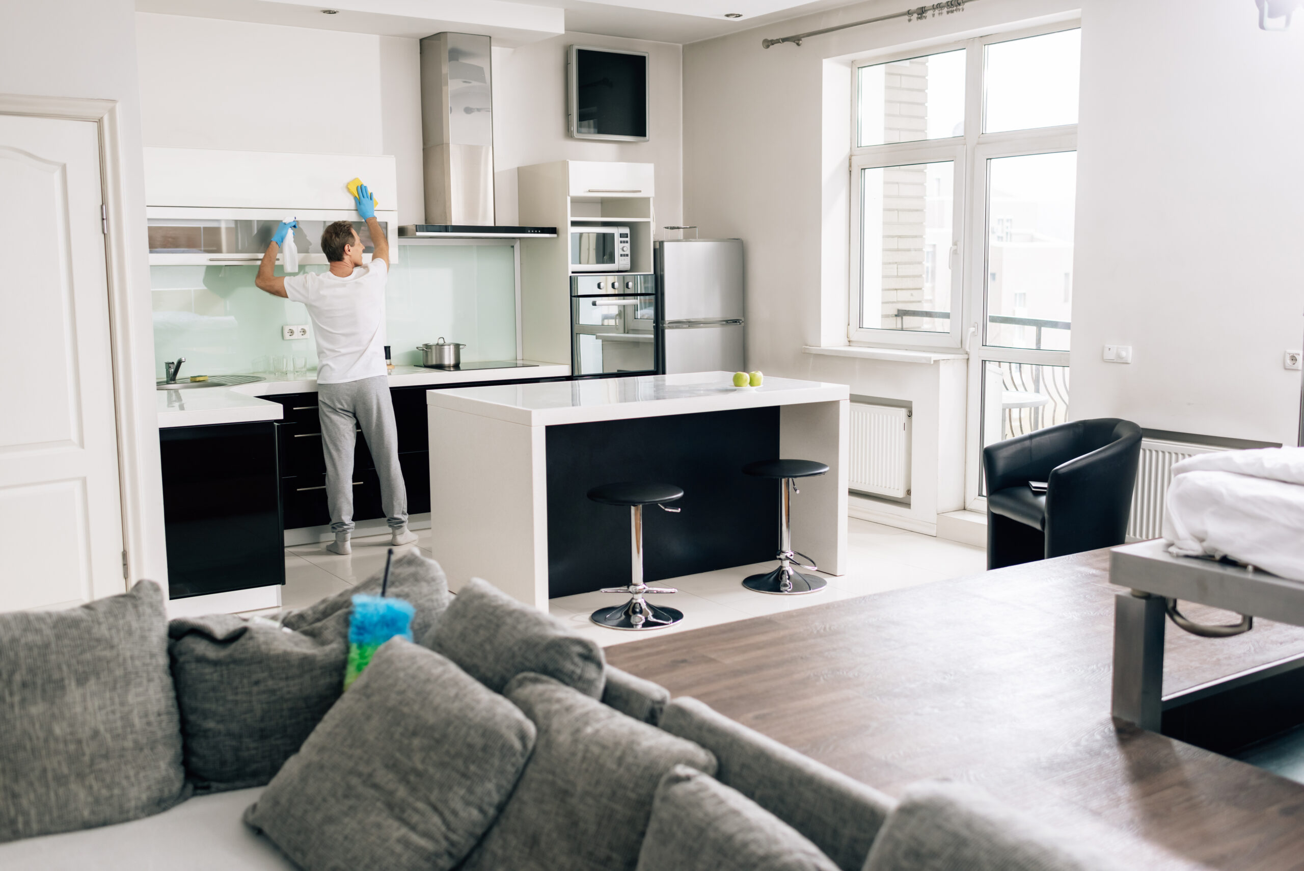 selective focus of man cleaning kitchen at modern home